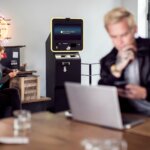 a man and a woman sitting at a table with a laptop